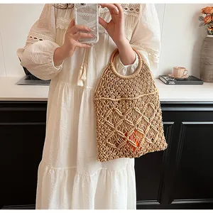 Detalle del bolso de malla tejido a mano con asa redonda de madera y estilo macramé