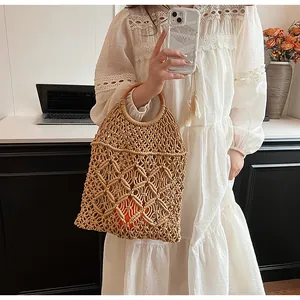 Detalle de bolso de malla tejida a mano con asas redondas de madera para el verano