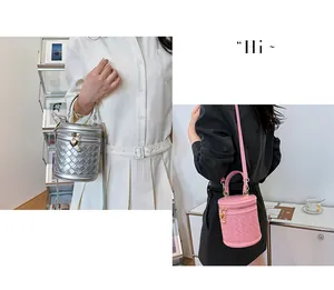 Détail de sacs seaux tressés en argent et rose avec des pendentifs en métal en cœur