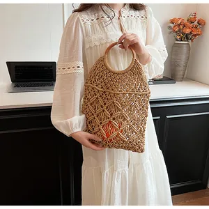 Detalle de bolso tote de malla tejida a mano con asas redondas de madera para verano