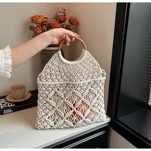 Detalle del bolso de macramé blanco con asas redondas de madera y malla bohemia