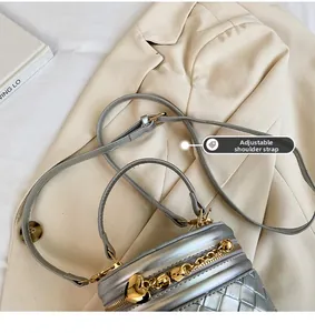 Détail du sac seau argenté montrant la texture tissée et la bandoulière réglable