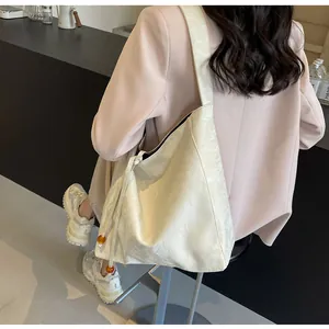 Detalle de bolso hobo con cordón lateral, cuentas de ámbar y textura de cuero suave