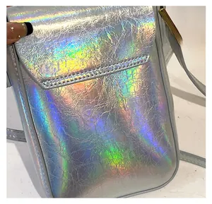 Detailed view of holographic mini crossbody bag showing textured pleated leather material