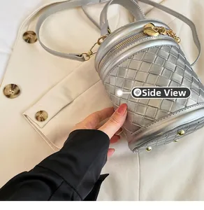 Vue latérale du sac seau en cuir tressé argenté avec fermeture cœur et pieds en métal