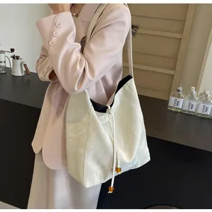 Detalle de bolso tote blanco con cordón de cuentas de ámbar e interior en contraste