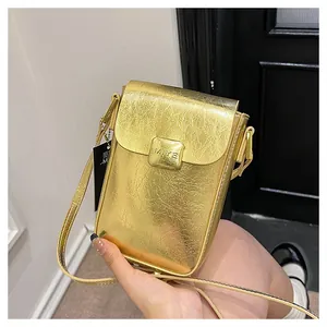 Detailed view of golden metallic mini crossbody bag with wrinkled texture and flap closure