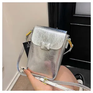 Detailed close-up of metallic silver mini crossbody bag with textured wrinkled finish