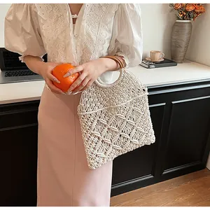 Detalle de bolso macramé blanco con asas redondas de madera y diseño entretejido