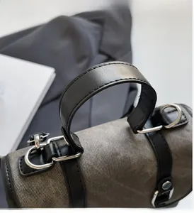 Detail of reinforced leather handle and silver metal hardware on a retro canvas backpack