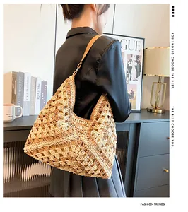 Détail d'un sac hobo en paille tissé à la main avec motif de diamant et cuir