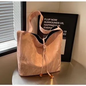 Detalle de bolso tote rosa claro con textura marmoleada y colgante de ámbar