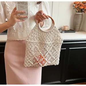 Detalle de bolso playero macramé con asas redondas de madera y forro naranja