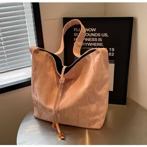 Detalle de bolso tote rosa arrugado con cordón ajustable y cuentas de color ámbar