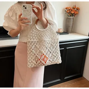 Detalle del bolso de algodón tejido en color crema con un asa redonda de madera maciza