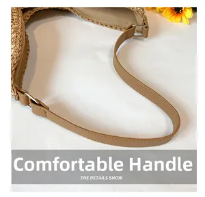 Détail du sac cabas en paille avec bandoulière en cuir et boucles métalliques argentées