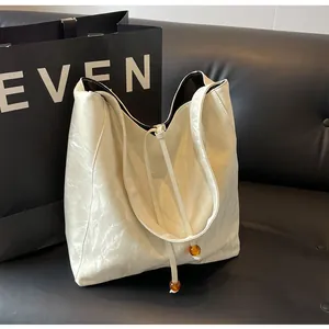 Detalle de bolso hobo blanco en cuero PU plisado brillante con cuentas de ámbar