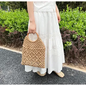 Detalle de bolso de macramé hecho a mano con asas redondas de madera y tejido calado