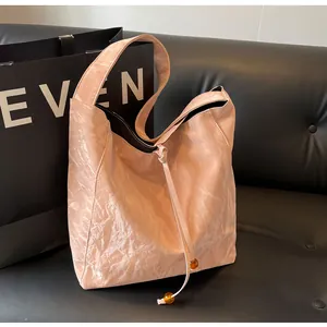 Detalle del bolso tote plisado rosa con cuentas de ámbar y textura rugosa