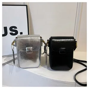 Detailed macro view of MIYE mini phone bags in silver and black wrinkled texture leather