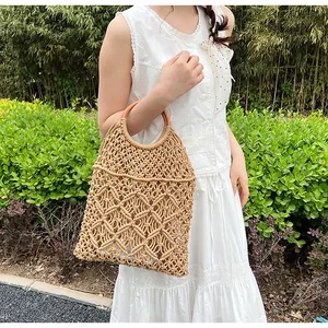 Primer plano del bolso de red tejido beige con asas redondas de madera en estilo veraniego