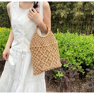 Detalle de bolso de malla beige tejido a mano con asas redondas de madera para las vacaciones
