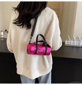 Pink metallic pillow bag worn cross-body style showing glossy wrinkled leather texture