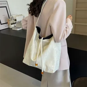 Bolso tote blanco minimalista con textura ondulada y cordón con cuentas de ámbar