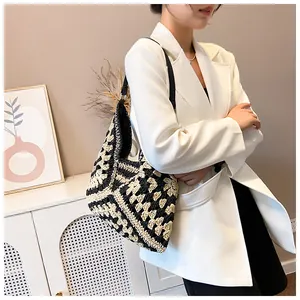Détail du motif au crochet géométrique noir et blanc sur le sac cabas en paille tissée