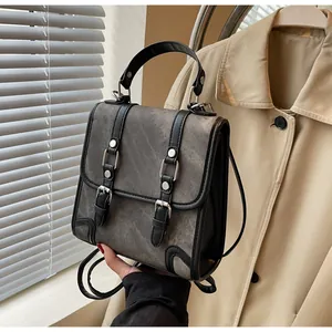 Detailed view of the retro backpack with silver buckles and black leather handle straps