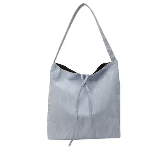 Bolso tote azul claro minimalista con textura plisada y detalle de cordón ajustable