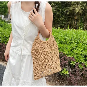 Detalle del bolso playero de macramé con diseño de rombos y asas redondas de madera