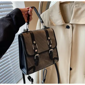 Detail of British style olive green satchel with metal buckle straps and top handle