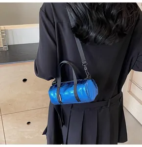 Detail of metallic electric blue mini barrel bag with black straps and logo label