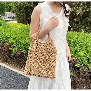 Detalle del bolso de malla hecho a mano con asas redondas de madera y diseño calado