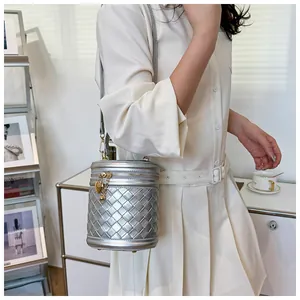 Détail du sac seau tressé argenté avec pendentif cœur et texture métallique chic