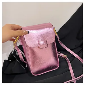 Detail of pink metallic phone bag showing textured crackle finish and square buckle