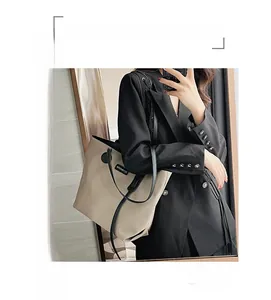 Mirror selfie showing the large beige nylon tote bag with black straps on shoulder