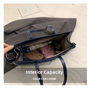 Spacious interior of blue denim tote bag with organized pockets for umbrella and phone