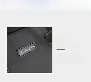 Detailed close-up of the silver brand logo on waterproof black nylon tote bag surface