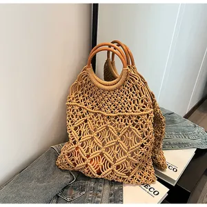 Detalle de bolso bohemio tejido a mano con asas de madera sobre fondo de tela vaquera
