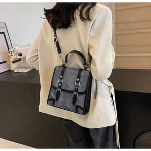 Detail of vintage gray-blue textured backpack with black leather trim and silver buckles