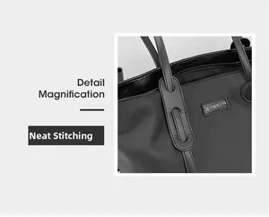 Detail magnification of neat stitching and leather handle on black nylon tote bag