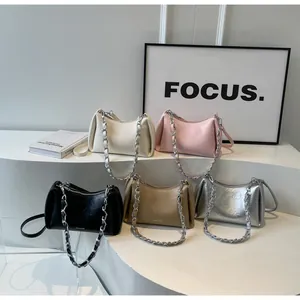 Detailed display of assorted pleated leather underarm bags with thick silver chains