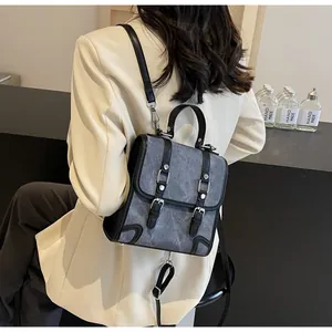 British style grey canvas backpack shown on model with vintage leather strap detail