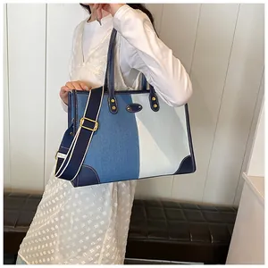Detail of multi-color denim tote bag with leather trim and wide adjustable strap
