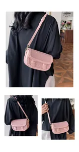 Detail of pink woven saddle bag with adjustable shoulder strap and textured flap finish