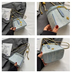 Detailed views of light blue tweed bucket bag with gold flower charms and chain strap