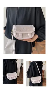 Detail of woven texture saddle bag in soft pink with golden hardware and leather strap