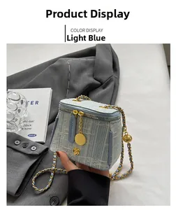Detailed close-up of light blue tweed bucket bag with golden chain and floral clasp
